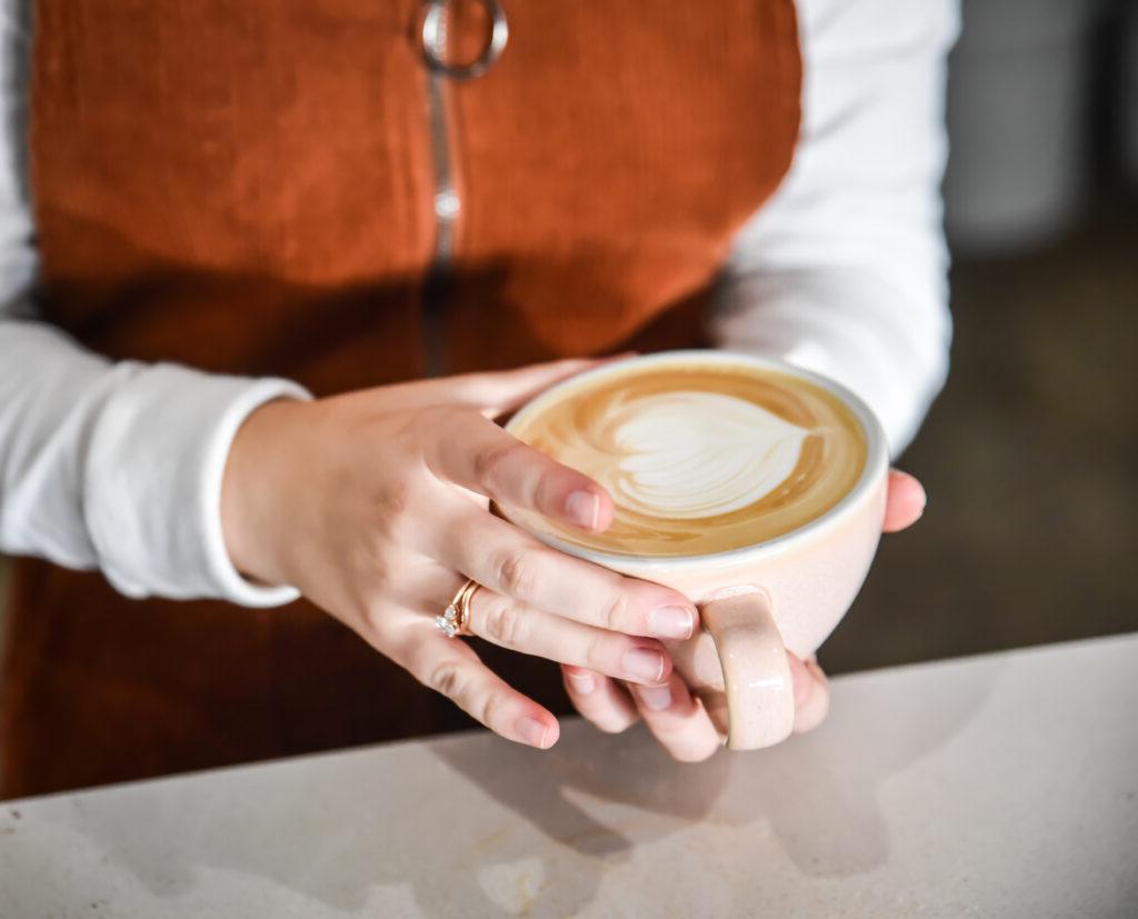 barista holds cappuccino